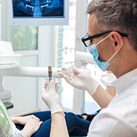 a dentist explaining how dental implants work in Pensacola