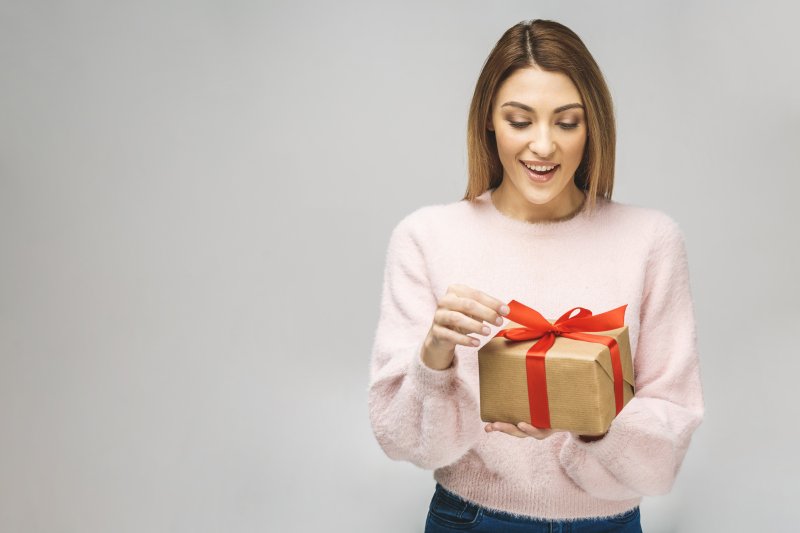 a woman smiling at a present