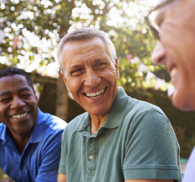 Man laughing with group of friends outdoors